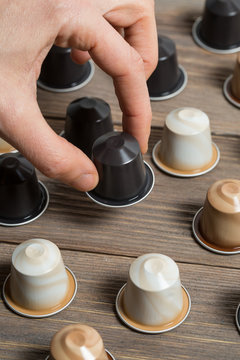Dita che afferrano capsula di caff&egrave;
