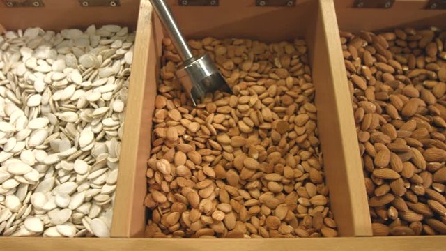 Peeled nuts and unpurified pumpkin seeds.
Smooth movement of the chamber along boxes with nuts and seeds: pumpkin seed, almond, apricot seeds, cashew, hazelnuts, walnut.