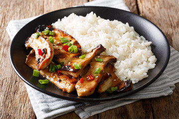 spicy king oyster mushrooms with chili and onions and rice garnish close-up. horizontal