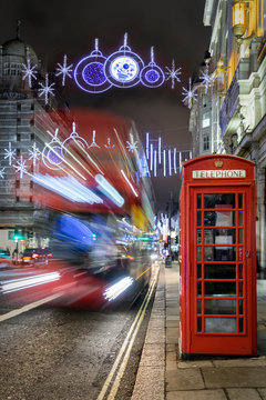 Rote Telefonzelle und Doppeldecker Bus in London mit weihnachtlich geschmückter Straße