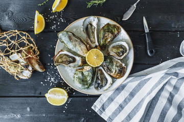 Open wet oysters on a plate with lemon © fotofabrika