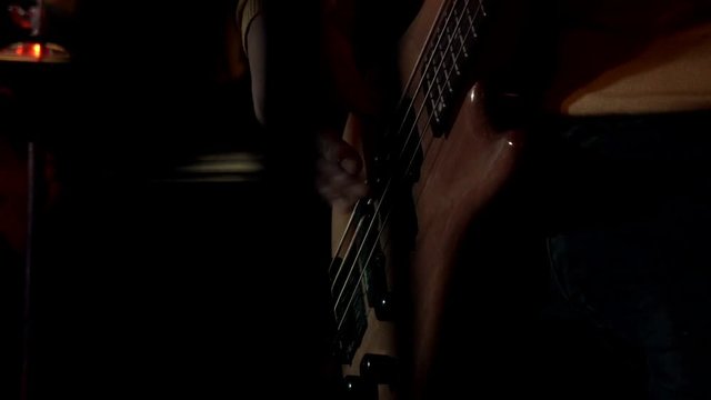 Rock musician plays solo on electric guitar on background drum plate