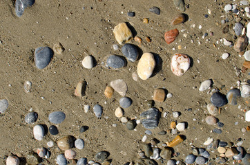 Colorful sea stones and sand background. Pebbles texture