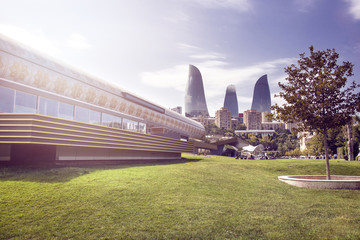 Azerbaijan, Baku: Modern Carpet Museum in the city center of the capital with park, trees and Flame Towers in the background.