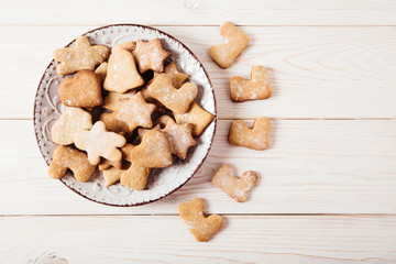 Plate with gingerbreads.Holiday and cooking concept.White wooden table.Top view.