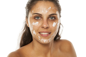young woman posing with cream on her face