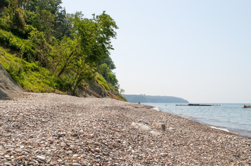 Fototapeta na wymiar Pebble beach at the steep coast near the village of Agoy