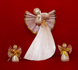 Straw angels on a red background