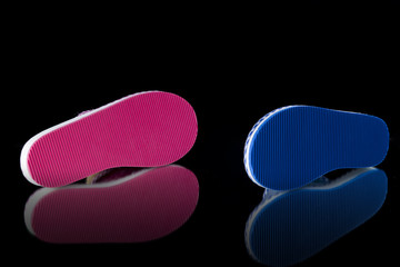 Female pink and blue slipper on black background, isolated product, comfortable footwear.
