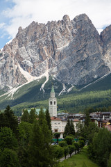 Fototapeta na wymiar Mountain Ridge in Italian Dolomites Alps, Trees and Typical Hous
