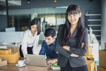 Young Asian Woman standing with smiling at workplace, Young Owner Woman Start up for Business Online, SME, Delivery Project, Woman with Online Business or SME Concept. Vintage tone.
