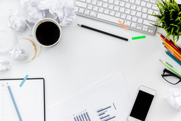 Clutter in office. Desk covered with crumpled paper and scattered stationery. White background top...
