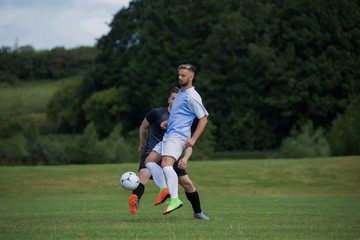 Obraz premium Football players playing soccer in the ground