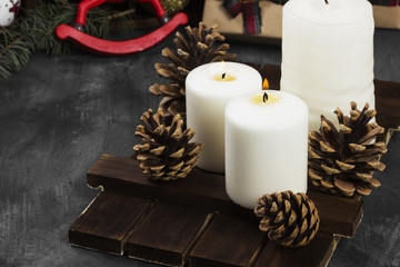 Burning candles and Christmas attributes on a dark background. Copy space