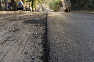 close-up of the process of repair of the road paving road asphalt application. Roadworks on laying of a new of asphalt.