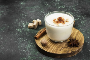 Christmas drink eggnog and ingredients on a green background. Copy space