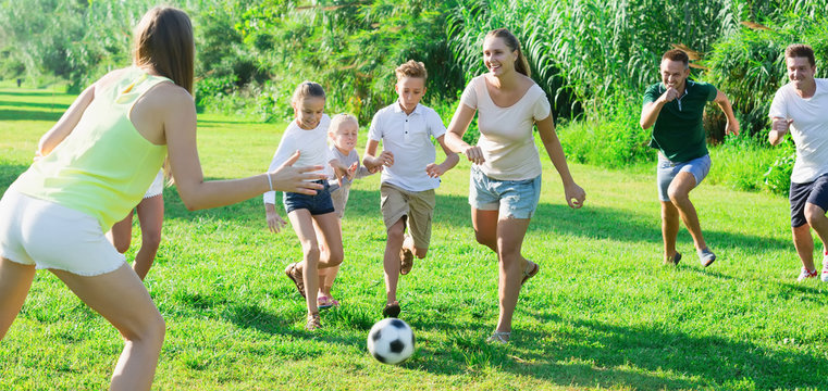 Family with kids  together outdoors playing football