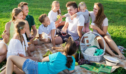 Portrait of  parents with children on picnic in nature at summer