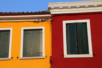 house with painted yellow and red wall and closed windows