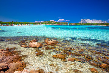 Lu Impostu beach with Isola Travolara in the background, red stones and azure clear water, San...