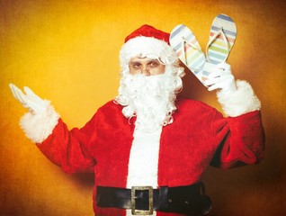 Funny Santa Claus holding flip flops