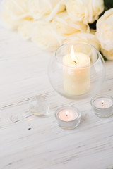 Fototapeta na wymiar Big palm candle in glass ball with white roses