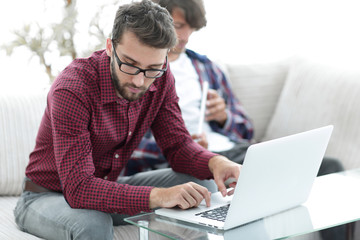 Portrait of two web designers discussing a project in front of a laptop