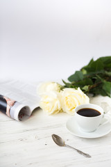 Coffee for breakfast or lunch with decorations, candles and flowers. white roses on the table and cup of coffee