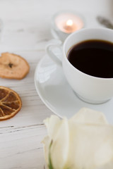 Coffee for breakfast or lunch with decorations, candles and flowers. white roses on the table and cup of coffee