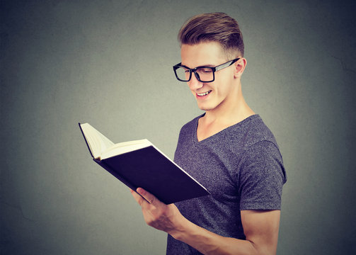 Portrait handsome man wearing glasses reading a book 