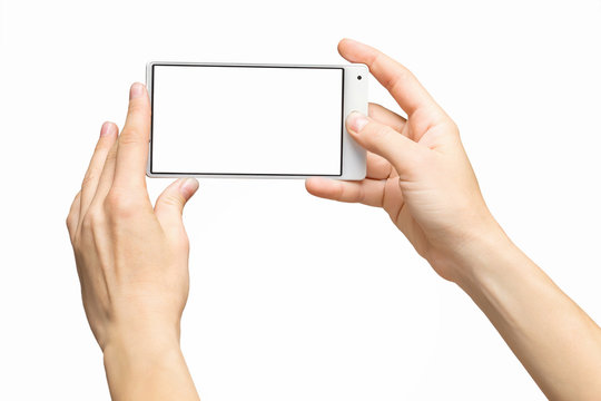 Mockup of female hands holding frameless cellphone with blank screen and making selfie at isolated background.