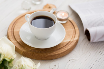 Coffee for breakfast or lunch with decorations, candles and flowers. white roses on the table and cup of coffee
