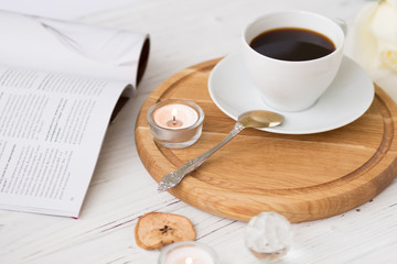 Coffee for breakfast or lunch with decorations, candles and flowers. white roses on the table and cup of coffee