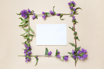 Flower frame made of bells on a beige background.