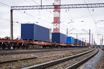 Fototapeta na wymiar Freight train with containers on the platform is standing on the railroad tracks