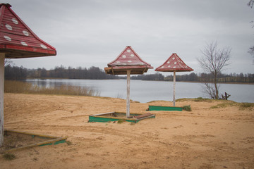 Beach wooden umbrellas on the beach with a red roof.