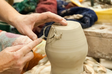  A potter takes off excess clay in the making of a vase.