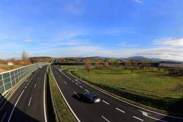 Panorama drogi, autostrady, linia horyzontu i góry.