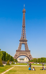 Fototapeta na wymiar Eiffel Tower in Paris, with grass lawn and people. Paris, France