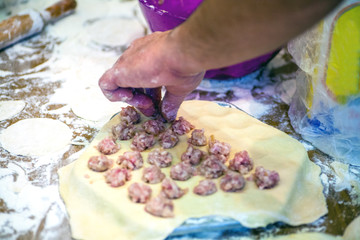 Preparation of dumplings at home in the kitchen for a family dinner in Russia Preparing, cooking, making homemade ravioli, pelmeni or dumplings with meat