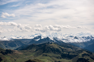 Gr&uuml;ne H&uuml;geln und Schneebedeckte Gipfel