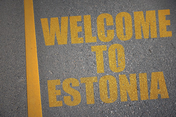asphalt road with text welcome to estonia near yellow line.