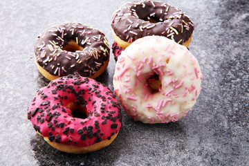 assorted donuts with chocolate frosted, pink glazed and sprinkles donuts