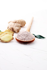 Fresh ginger root and ground ginger spice on white background.