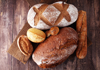 bakery concept with bread and bread rolls on wooden background.