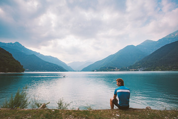 tourist cyclist rests near the mountain lake Lago di Ledro in Italy in the vicinity of lago di Garda
