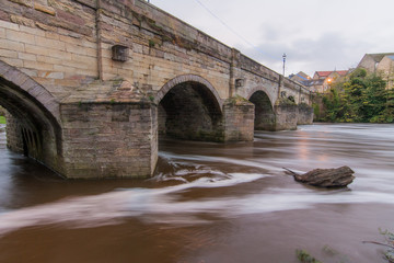 A partially submerged treetrunk approaches the bridge during Storm Brian in the River Wharfe in Wetherby.
