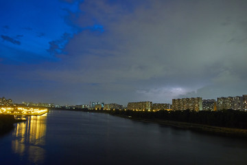Cityscape at dusk with thunderstorm over apartments buildings