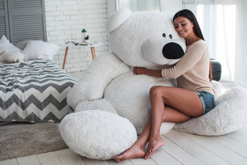 Girl cuddling with giant teddy bear on sale