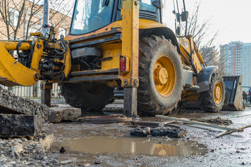 Workers excavate the pit with an excavator. Road repair.